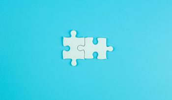 Jigsaw puzzle pieces on blue background with copy space for text. solutions, mission, successful, goals, cooperation, partnership and strategy concept